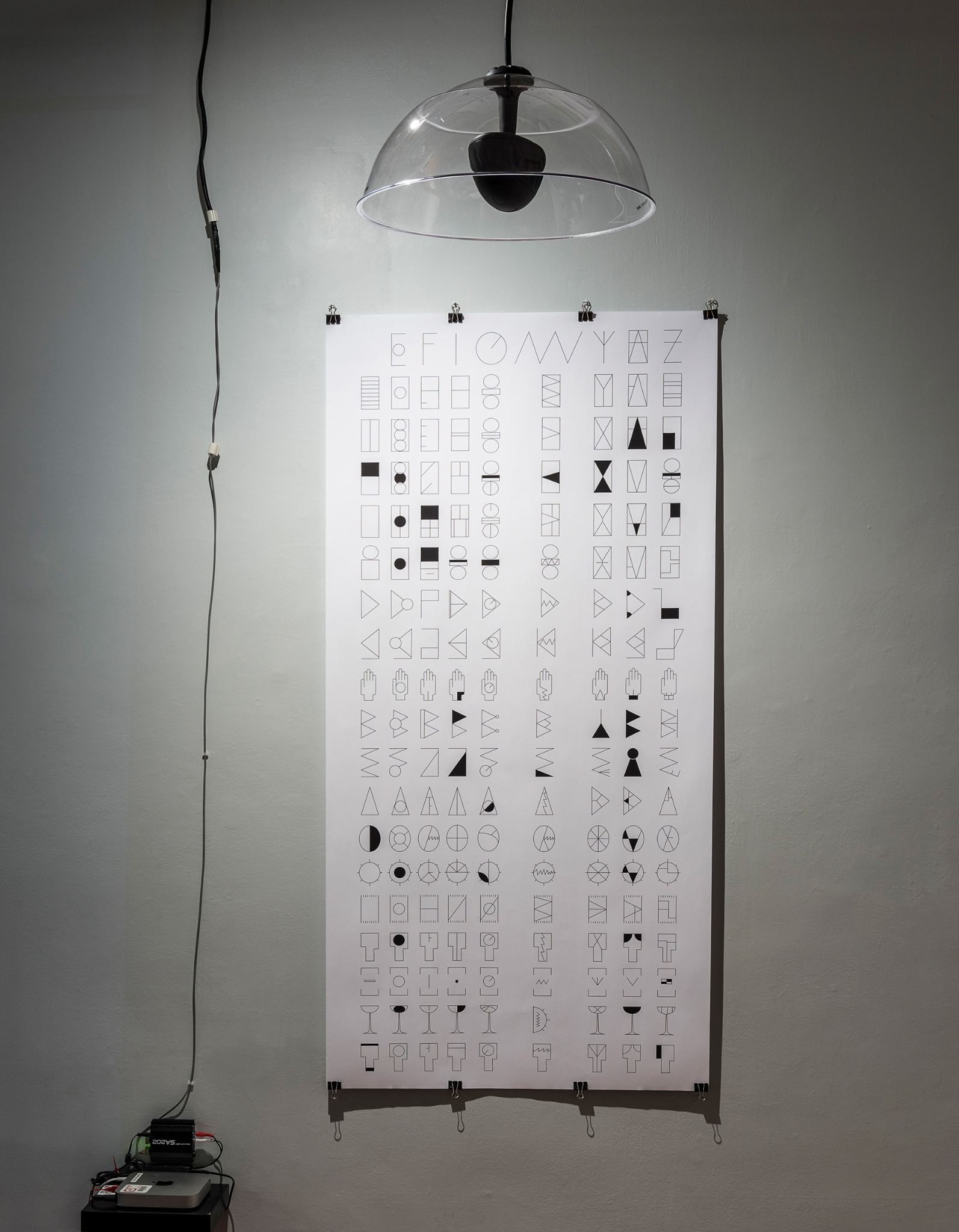 Syllabary work installed beneath a hanging speaker