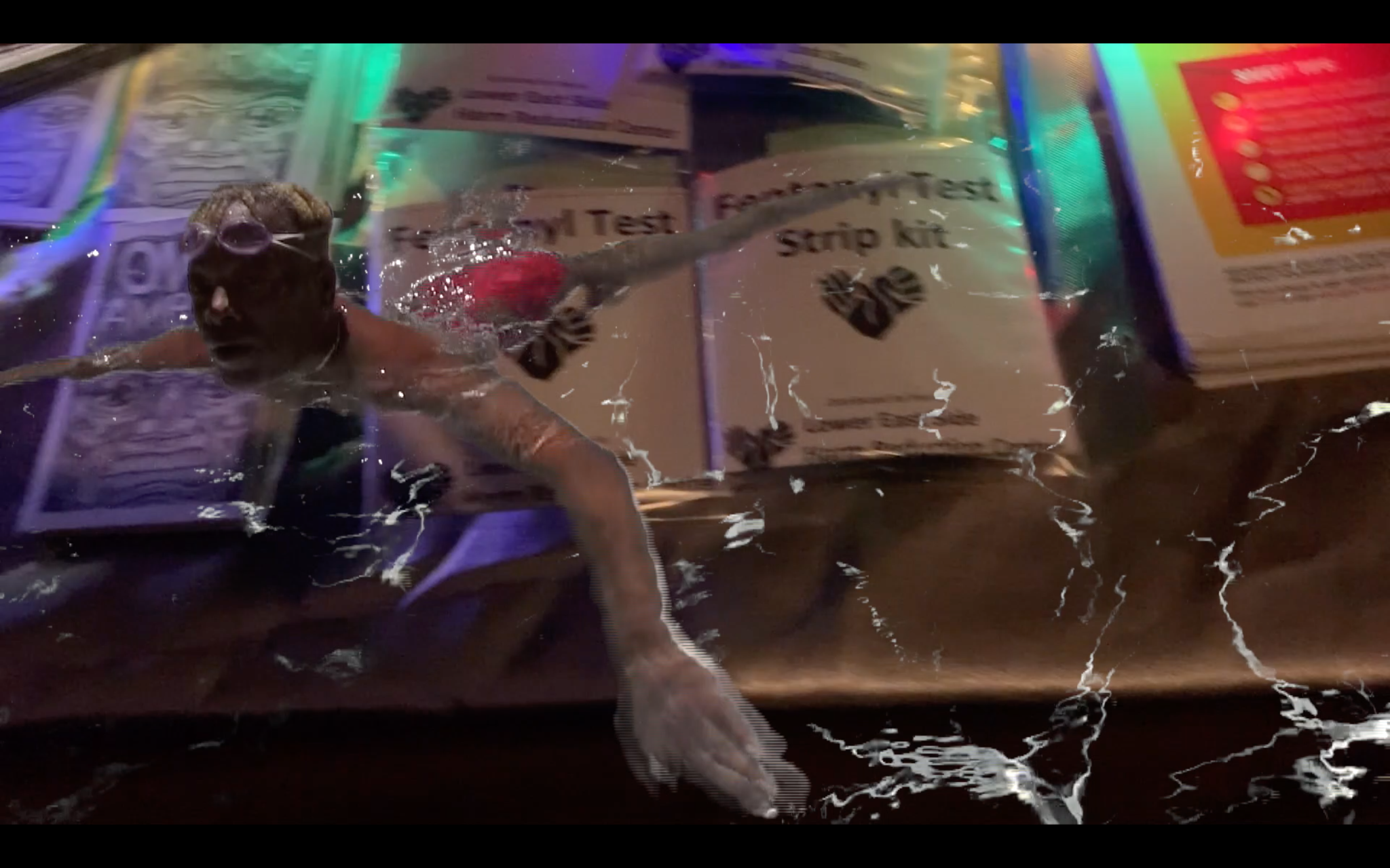 Still from eye, virus combining a swimmer with imagery from a mobile testing site