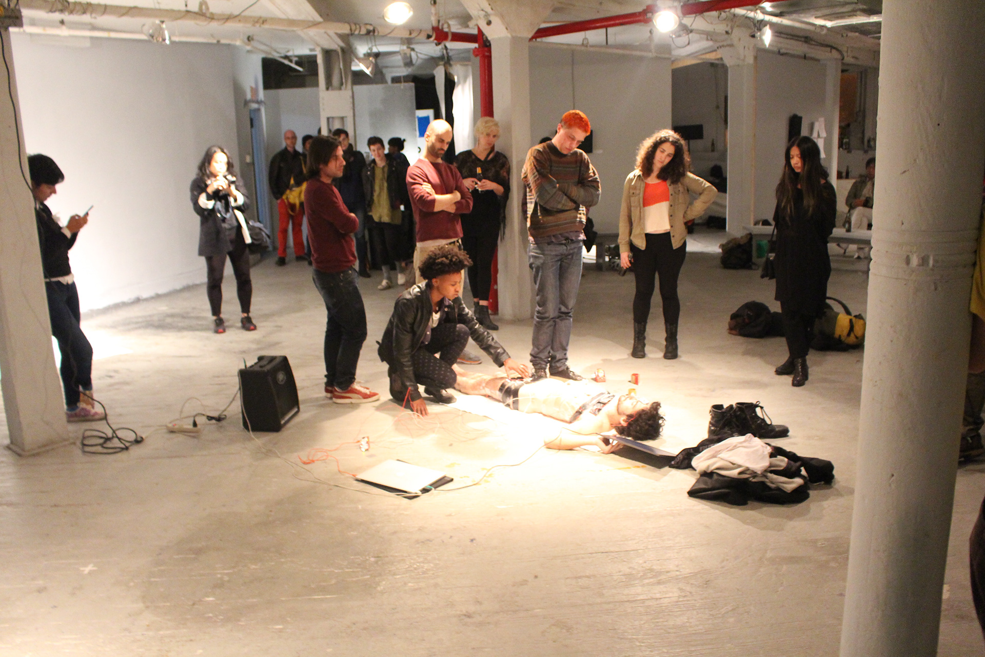 Wide view of the performance with audience members gathered around the artist